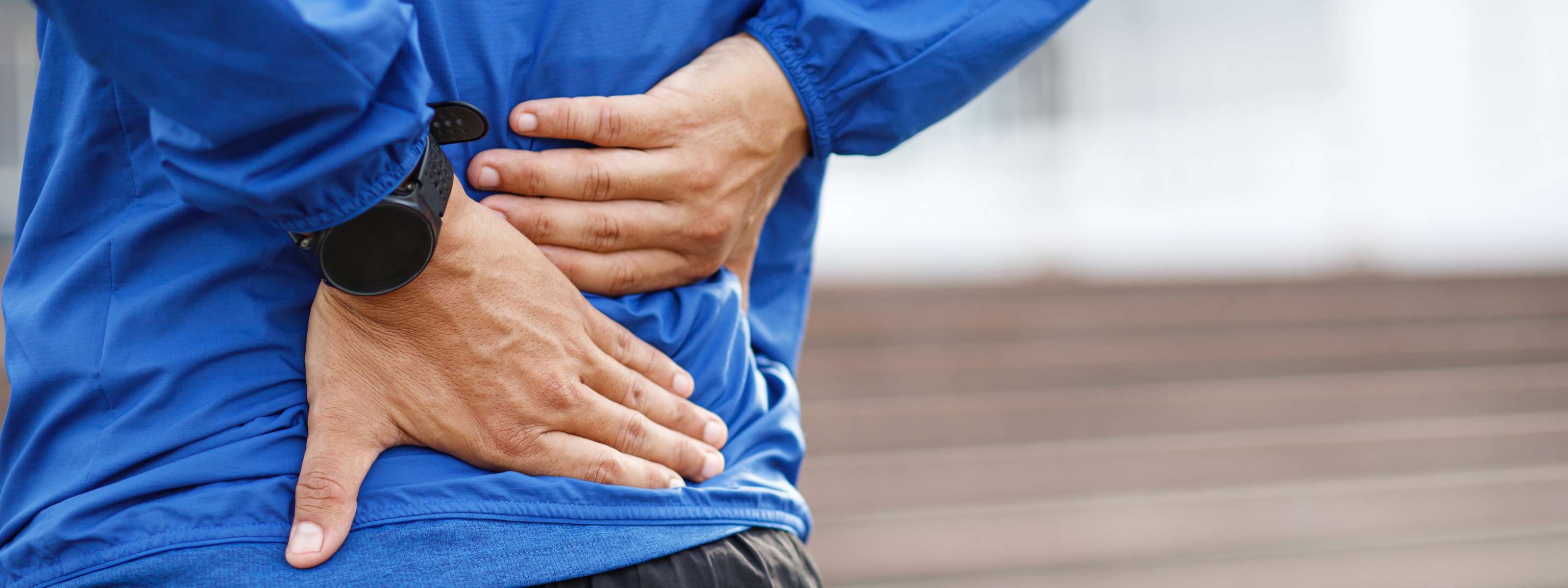 Homme tenant son bas du dos en raison d’une douleur lombaire.