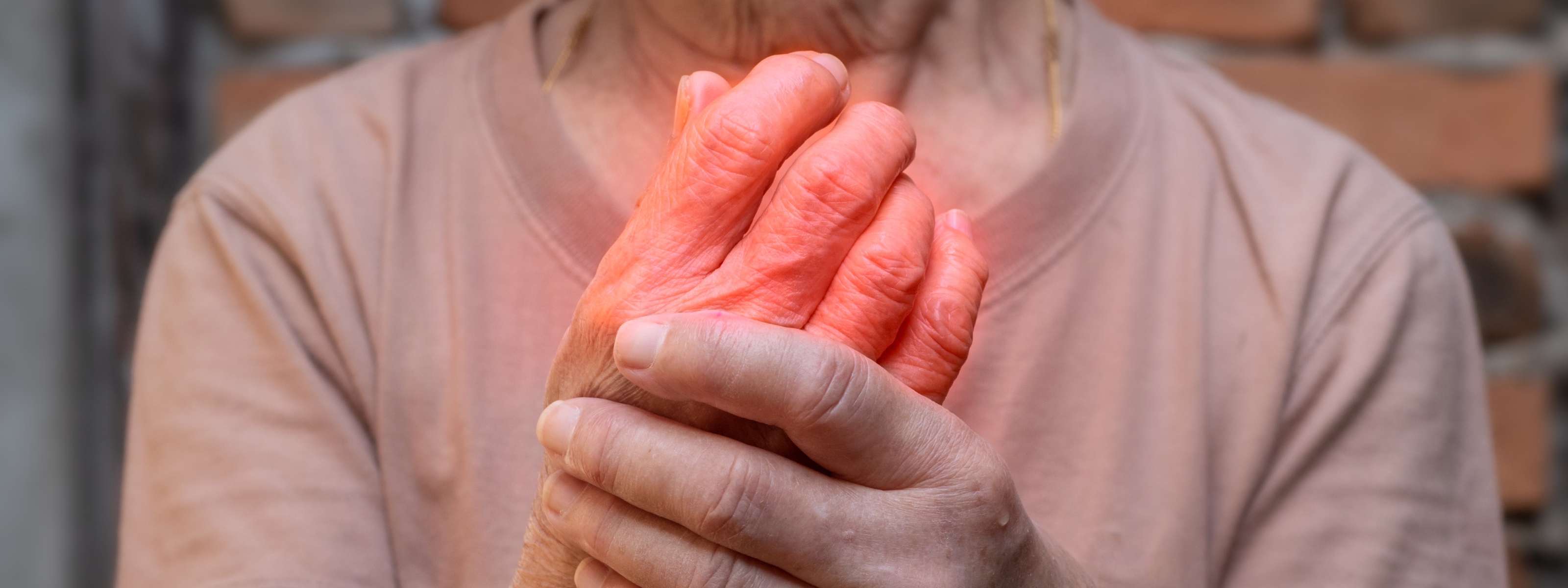 Personne âgée tenant sa main en raison de douleurs articulaires.