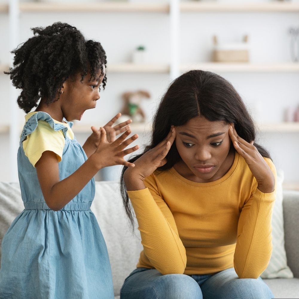 Enfant très énergique face à sa mère fatiguée qui se masse les tempes — illustration des défis du TDAH au quotidien en famille.