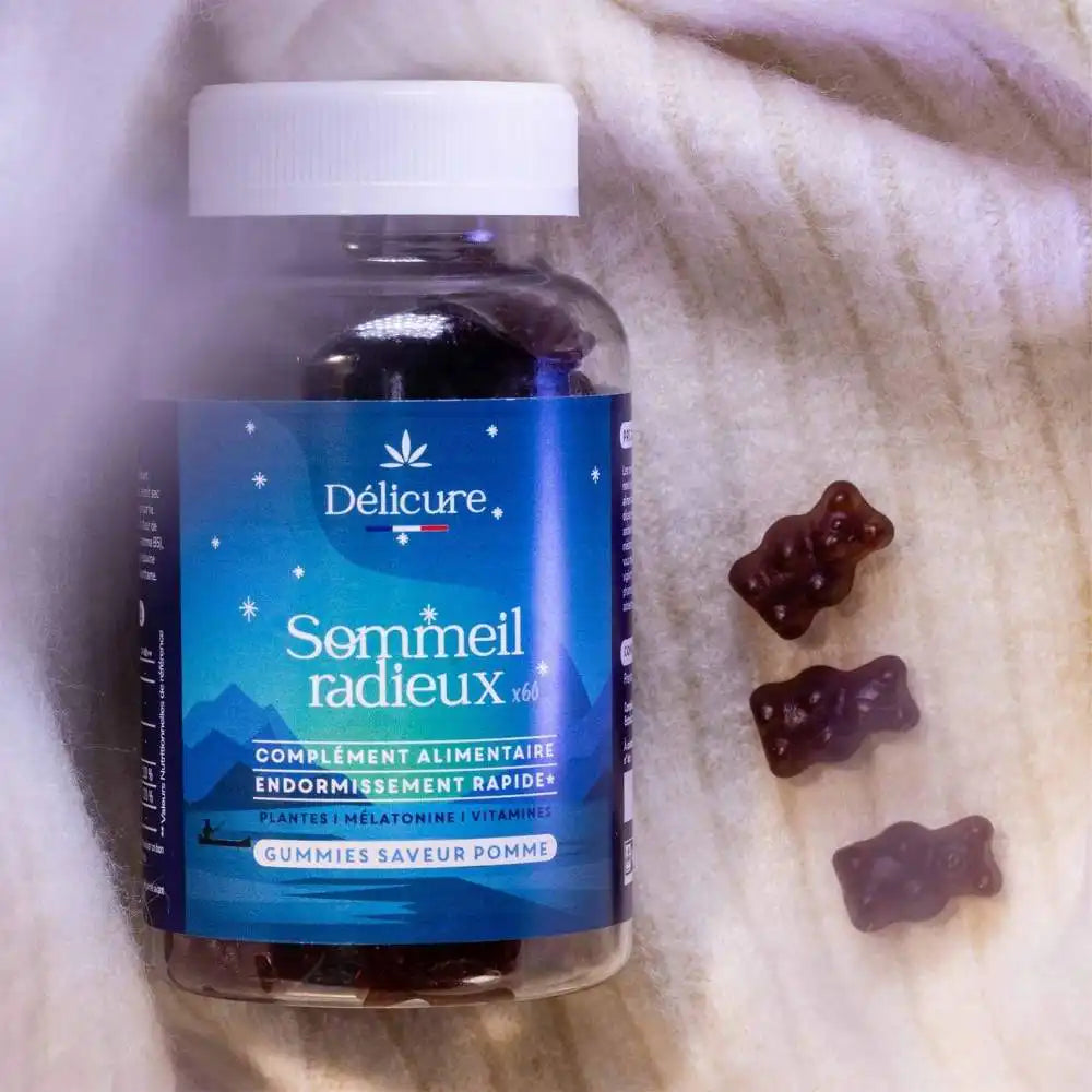 Pot de gummies Sommeil Délicure posé sur un lit, entouré de quelques oursons, évoquant la routine bien-être avant le coucher.