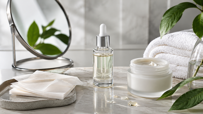 Produits de soin pour peau grasse et excès de sébum, avec sérum, crème et papiers matifiants dans une ambiance naturelle et épurée.