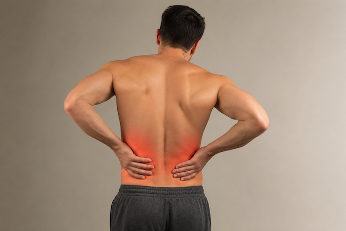 Homme se tenant le bas du dos avec les mains au niveau des flancs, illustrant la difficulté à distinguer une douleur aux reins d'un mal de dos.
