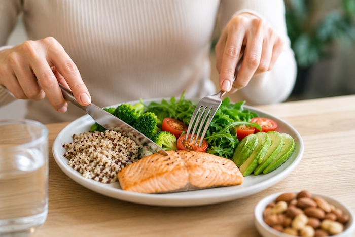 Assiette équilibrée composée de saumon, quinoa, avocat et légumes frais favorisant une meilleure satiété